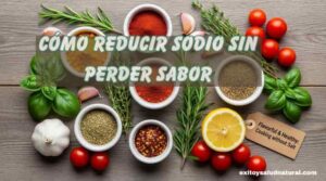 Variedad de especias en cuencos (cúrcuma, pimentón, chile), ajo, romero, tomillo, albahaca, limones y tomates cherry sobre una tabla de madera.